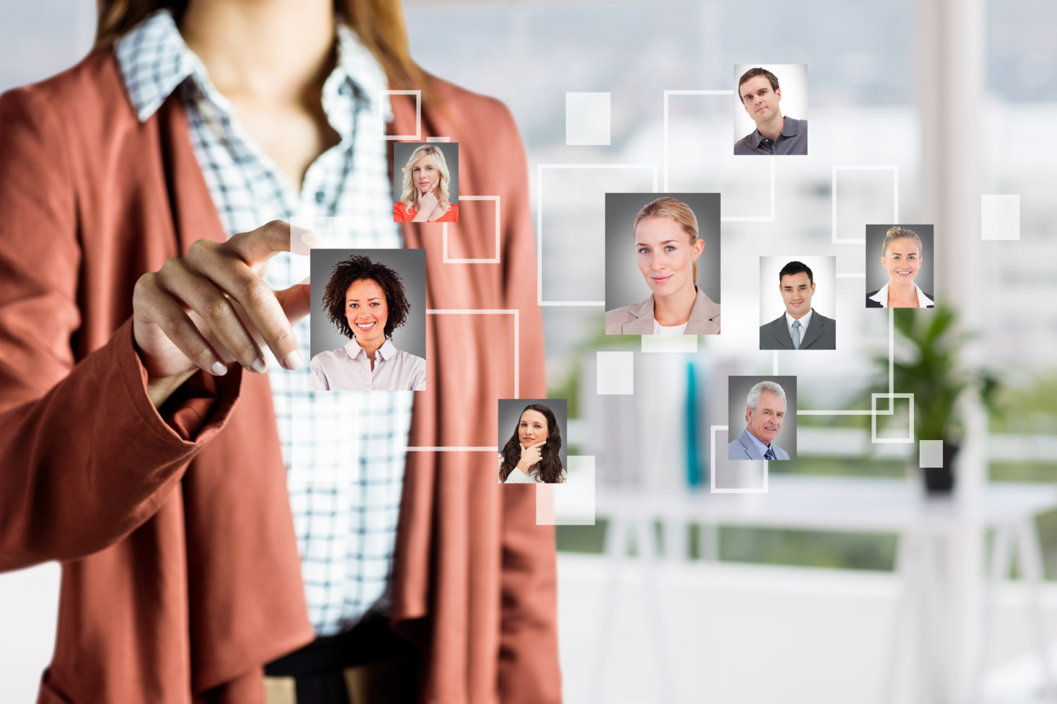Person interacting with a holographic display of professional profiles